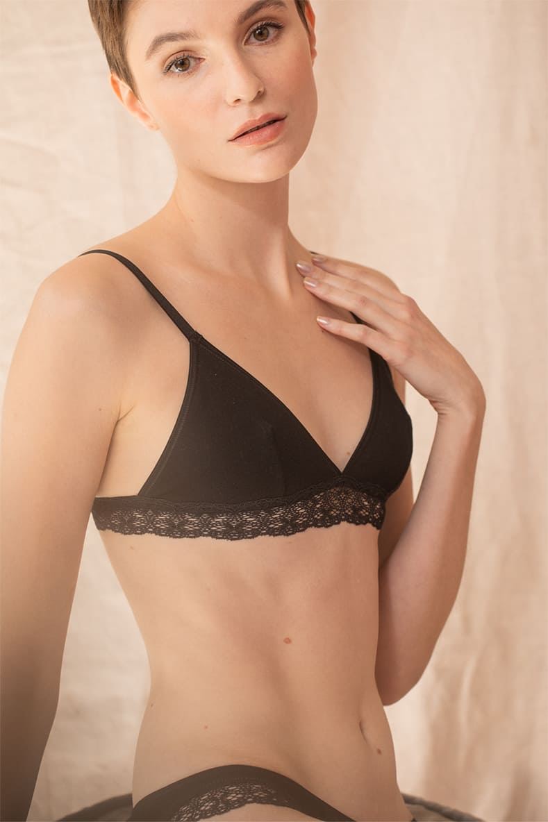 Jeune femme de face porte un soutien-gorge noir en coton biologique.