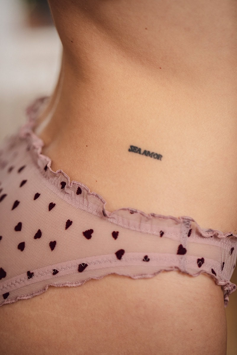 Détail d'une culotte froncée rose ornée de petits coeurs.