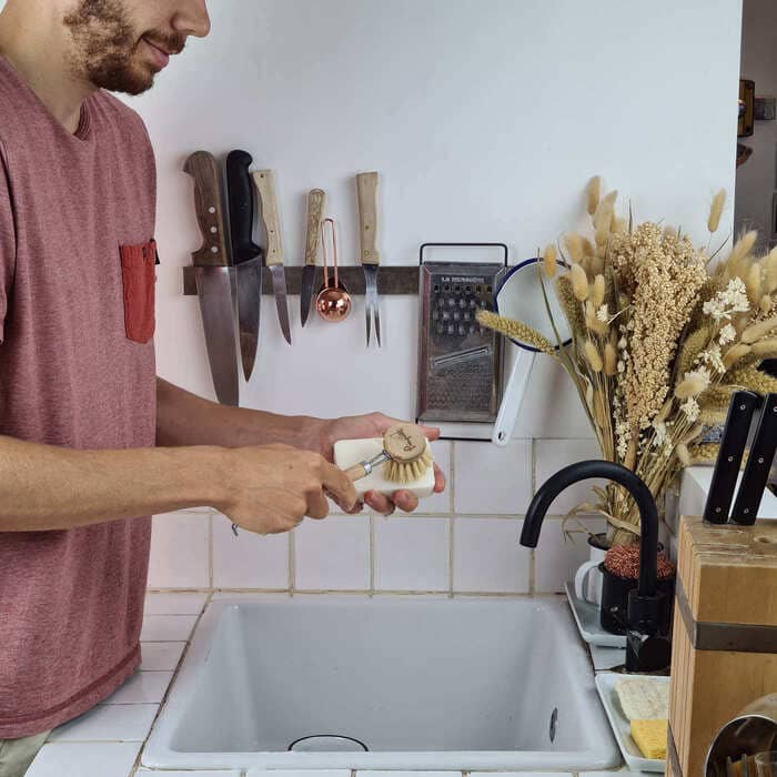 Laver sa vaisselle avec une brosse en bois