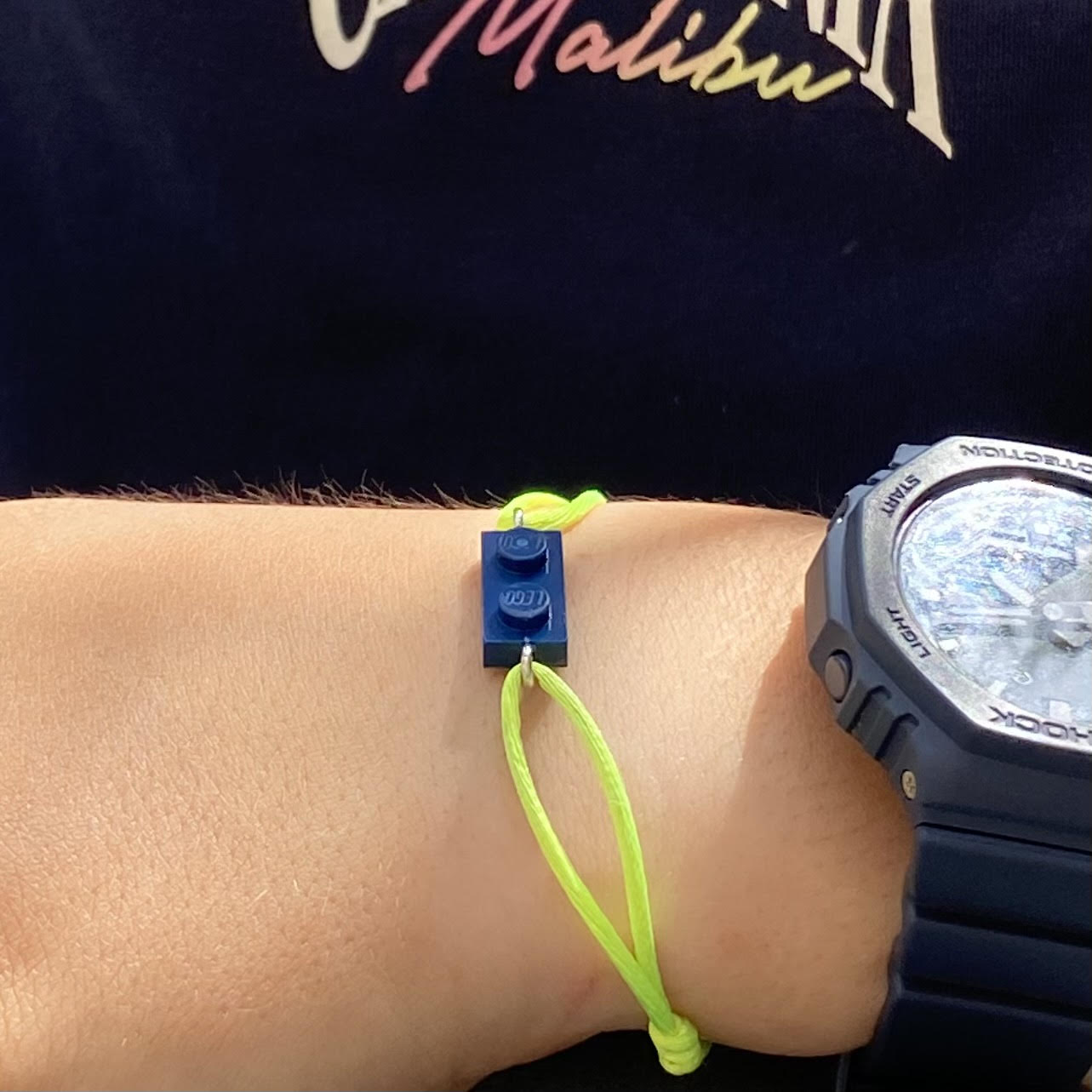 Fluorescent bracelet with a Lego® and an adjustable cord