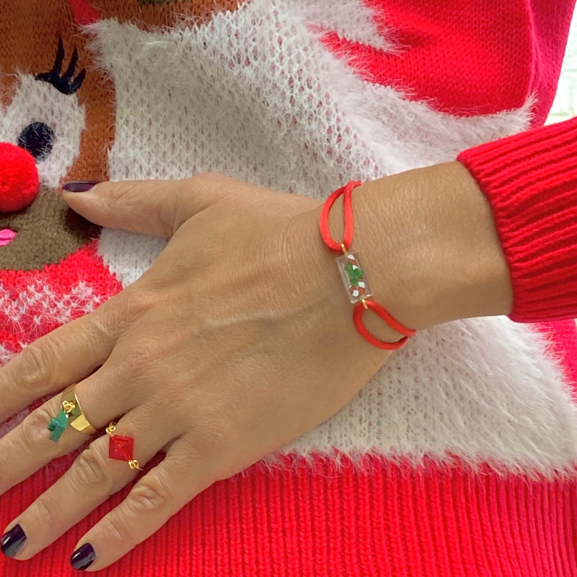 Bracelet spécial Noël avec un sucre d'orge imprimé sur une brique de Lego authentique. Le bracelet se règle avec un cordon rouge ajustable coulissant facilement. Les bagues sont vendues séparément.