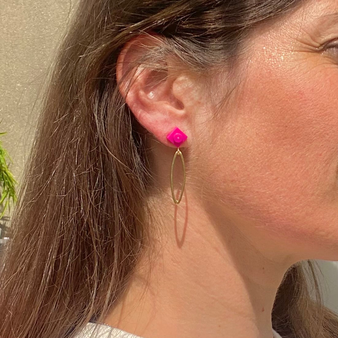 Boucle d'oreilles pendante avec un ovale en laiton doré suspendue à une brique de Lego 1x1 plate rose pivoine ou fuschia. Elle se coordonne parfaitement avec un style rose, une tenue violette à la mode.