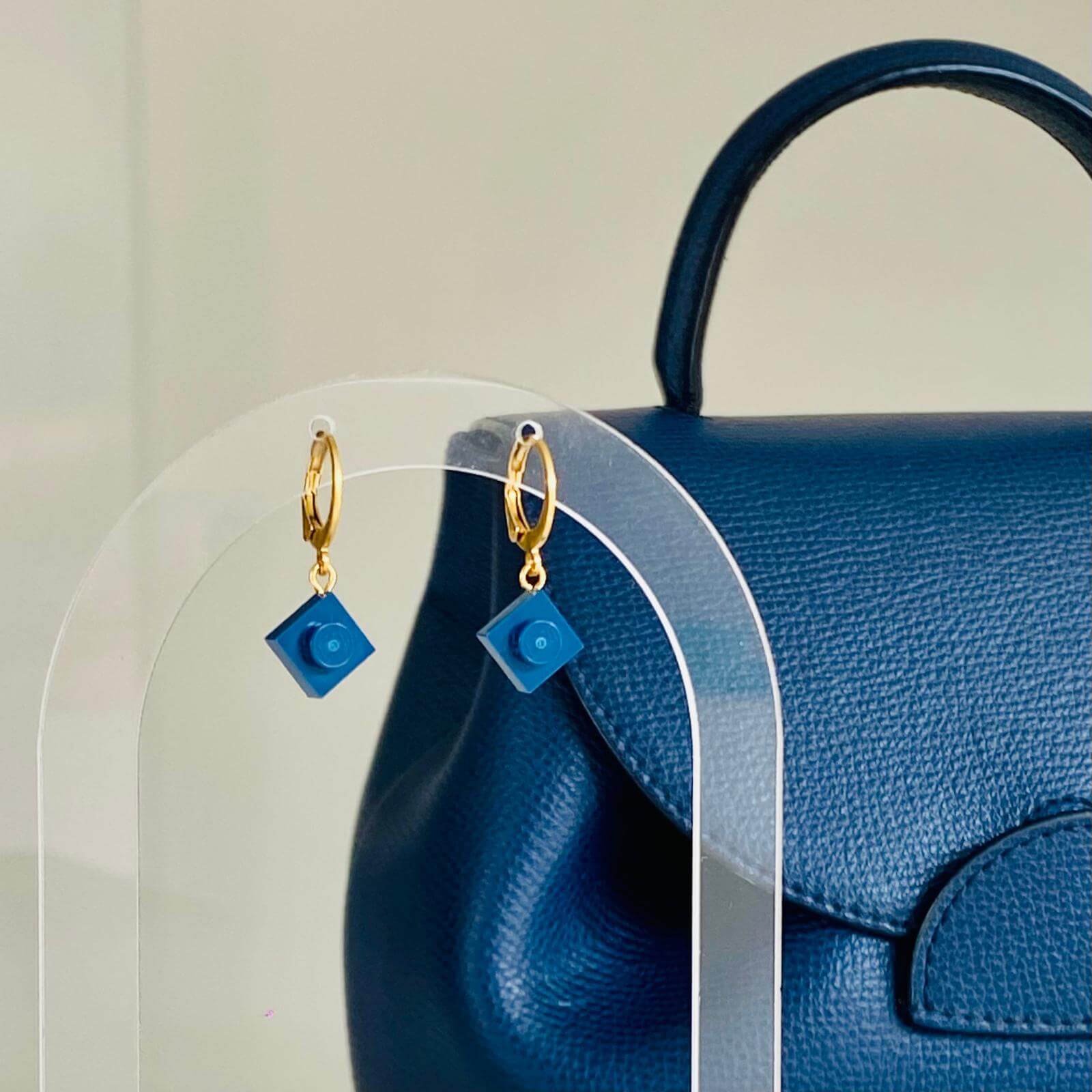 Boucles d'oreilles forme de dormeuses ou mini créoles en acier inoxydable avec une brique Lego 1x1 bleu marine. Des boucles d'oreilles assorties à mon sac Polène ! Boucles d'oreilles idéales pour faire du sport, aller au bureau en vélo, elles tiennent parfaitement à l'oreille et sont très légères.