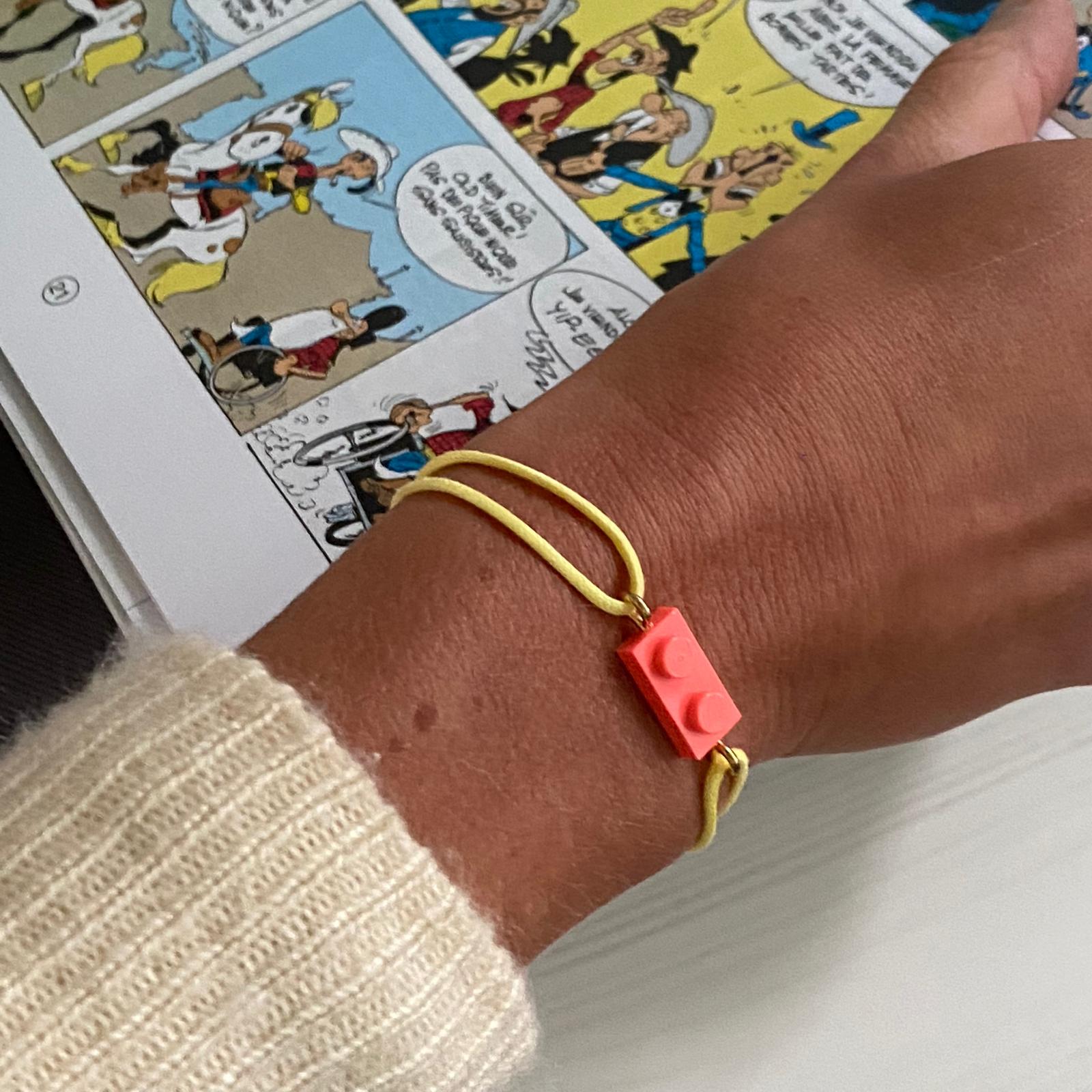 Fluorescent bracelet with a Lego® and an adjustable cord