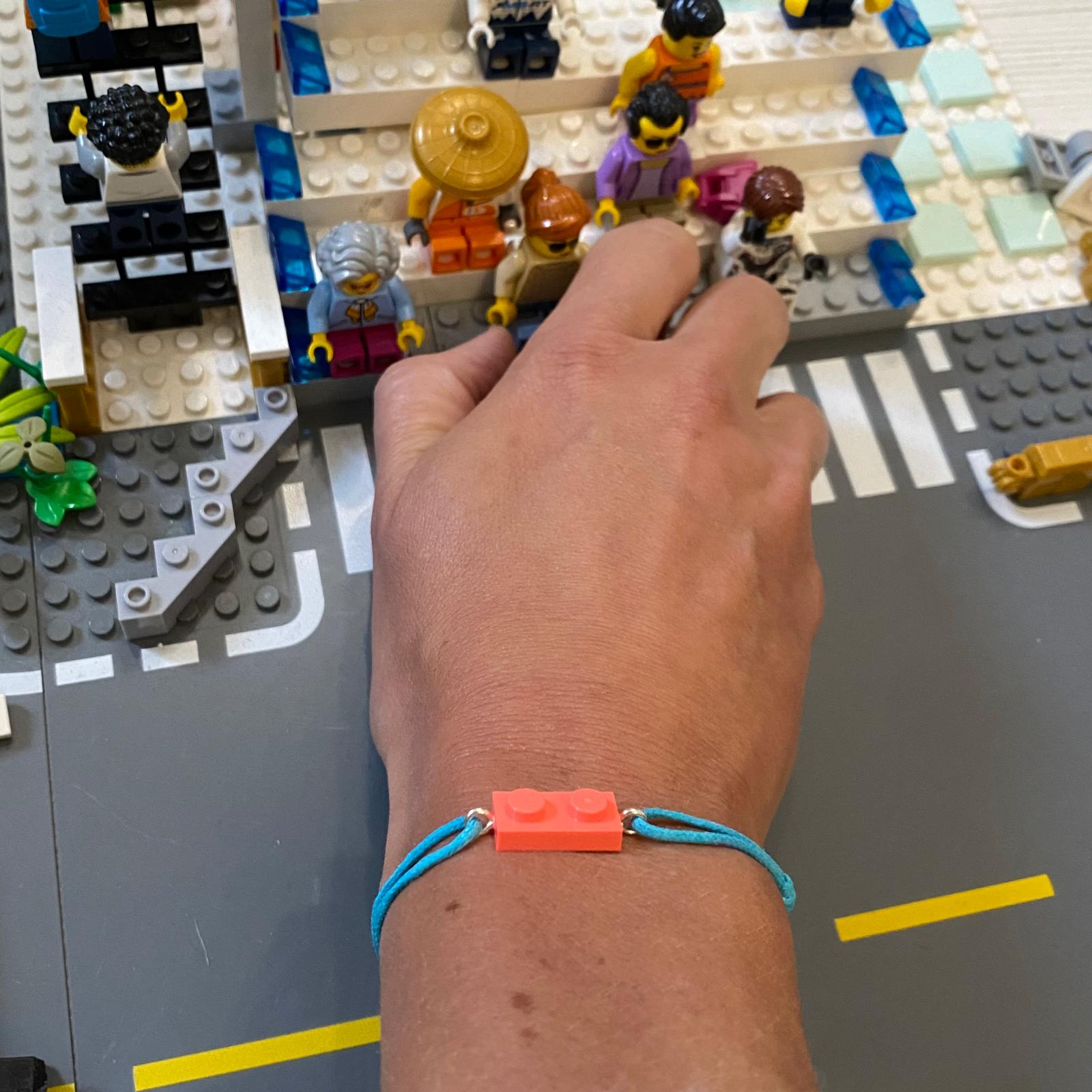 Fluorescent bracelet with a Lego® and an adjustable cord