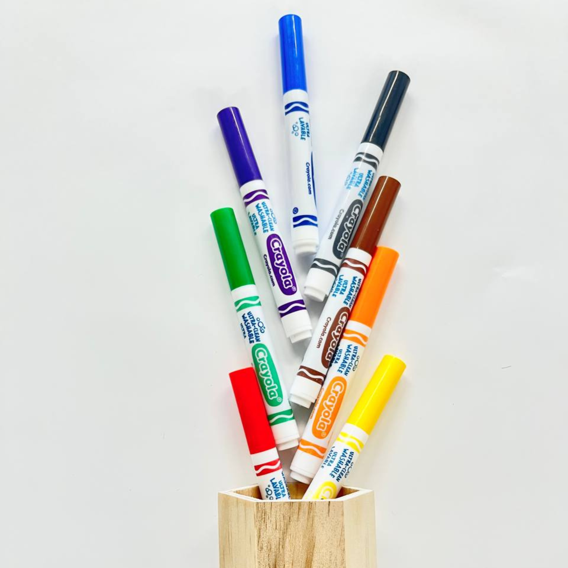 Feutres à l'eau Crayola sortant d'un pot en bois clair