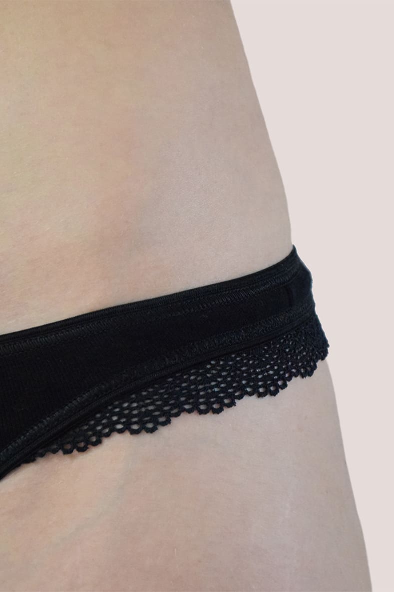 Détail de dentelle du string noir Elle, de la marque de lingerie éthique Olly. 