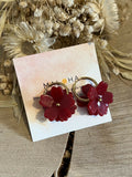 Large golden hoop earrings & their big red flowers