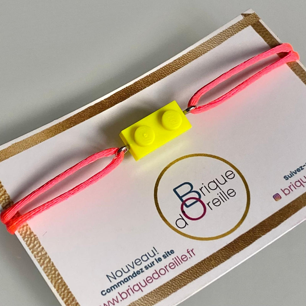 Fluorescent bracelet with a Lego® and an adjustable cord