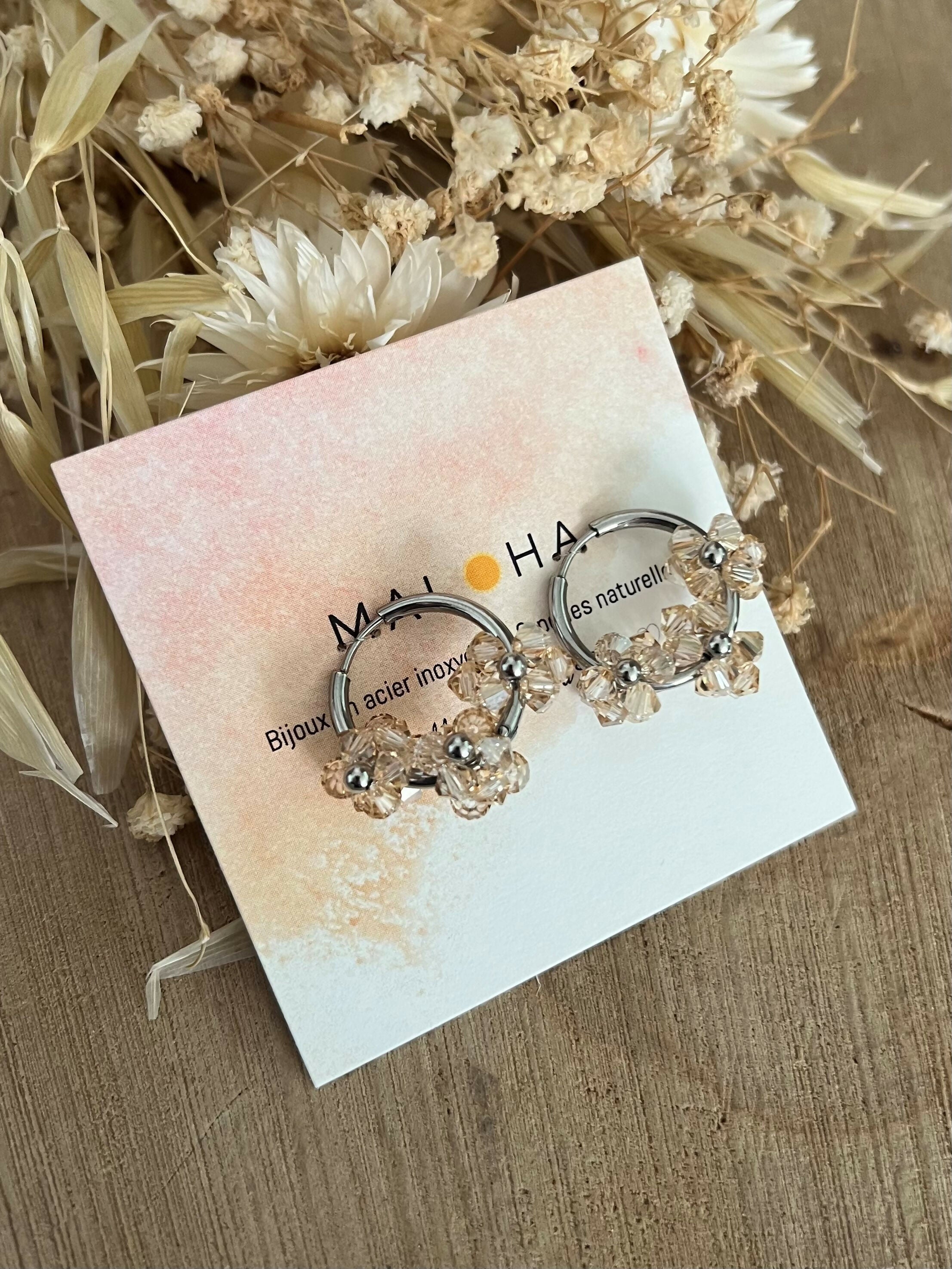 Large silver hoop earrings with light beige glass flowers